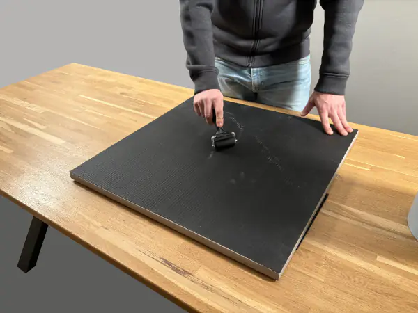 Andrücken der aufgebrachten Personenschutzmatte auf 2cm Feinsteinzeug